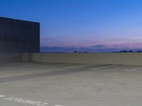 empty parking lot with sunset in background, taken from the back of the vehicle parking deck