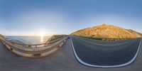 an empty road with hills and ocean in the background at sunset in front of a large cliff