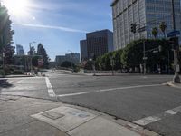 the sun is shining on an empty street in a city area and people are crosswalking