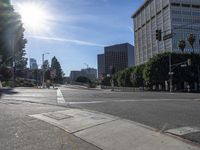 the sun is shining on an empty street in a city area and people are crosswalking