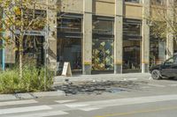 there is a building with a glass front in the middle of the street and people walking