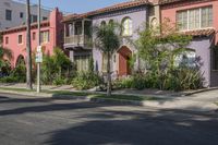 the view of a neighborhood's colorful buildings from down the street in front of the curb