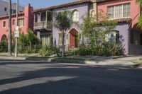 the view of a neighborhood's colorful buildings from down the street in front of the curb