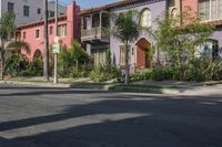 the view of a neighborhood's colorful buildings from down the street in front of the curb