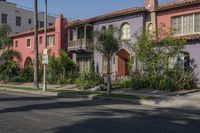 the view of a neighborhood's colorful buildings from down the street in front of the curb