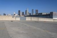 an empty parking lot with city skyline in the background on a sunny day with no people or cars