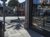 the sidewalk in front of a building on a street corner with a sign that says hannaie ice creams