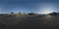 a view of an empty parking lot taken in a fish eye lens effect with the sky and clouds