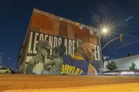 a wall that has some kind of art on it with the name of a basketball game in front