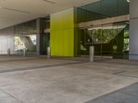 an empty building is decorated in a bright green colorway, including several glass panels