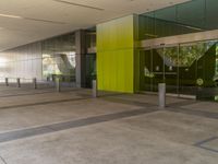 an empty building is decorated in a bright green colorway, including several glass panels