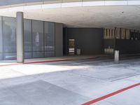 a large empty parking garage with red lines around it in front of a gray building