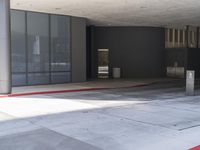 a large empty parking garage with red lines around it in front of a gray building