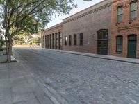 an empty street with lots of brickwork and trees on either side of the road