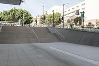 a man on a skateboard going down stairs in front of a building with trees