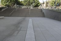 a man on a skateboard going down stairs in front of a building with trees