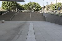 a man on a skateboard going down stairs in front of a building with trees