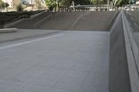 a man on a skateboard going down stairs in front of a building with trees