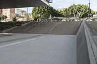 a man on a skateboard going down stairs in front of a building with trees