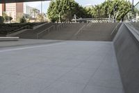 a man on a skateboard going down stairs in front of a building with trees