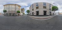 a fish eye lens view of the street in an urban city with tall buildings and trees