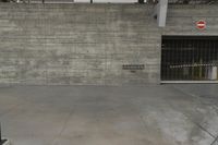 a concrete wall in an empty parking garage area at a construction site on a sunny day