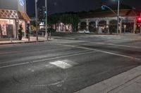 the lights on the buildings are green and bright at night time at a busy crosswalk