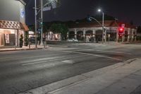 the lights on the buildings are green and bright at night time at a busy crosswalk