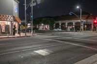 the lights on the buildings are green and bright at night time at a busy crosswalk