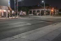 the lights on the buildings are green and bright at night time at a busy crosswalk