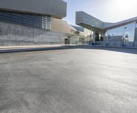 empty parking lot with modern buildings in the background and sun shining on buildings behind it