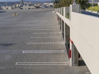 a parking lot next to an elevated parking area near some houses and mountains in the distance