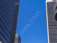 planes are flying in formation in an air above some large buildings while the city skyscrapers look like they are in the sky