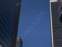 planes are flying in formation in an air above some large buildings while the city skyscrapers look like they are in the sky