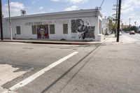 a painting of a man that has just completed a mural on a building is painted by a street corner artist