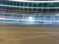 blurry lights from cars on a city street at nighttime, with buildings behind