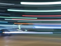 blurry lights from cars on a city street at nighttime, with buildings behind