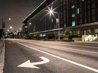 a white arrow symbol on the street with buildings and night sky in the background of this photo