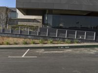 a skateboarder riding through a parking lot near a building on a sunny day