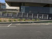 a skateboarder riding through a parking lot near a building on a sunny day