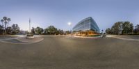 a wide angle view of the outside of the building, with a curved road in front