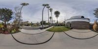 a fish eye view of a skate park with a curved concrete deck and palm trees in the background