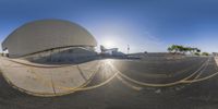 a panorama fish eye view looking out on a half - circular ramp at a skate park