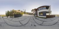 a skateboard ramp on the side of a house on a hill with a view of a home behind it