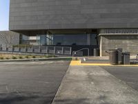 a person standing next to a parking lot near some stairs and tables outside the building