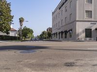 the view along a city street showing a building and a few cars on it and the street light