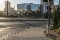 a stop light on the corner of an empty city street and another in the background