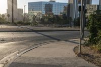 a stop light on the corner of an empty city street and another in the background