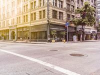 an empty city street filled with tall buildings and trees on the side of the road