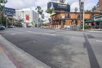 empty street in downtown with buildings and tall palm trees on either side of the road